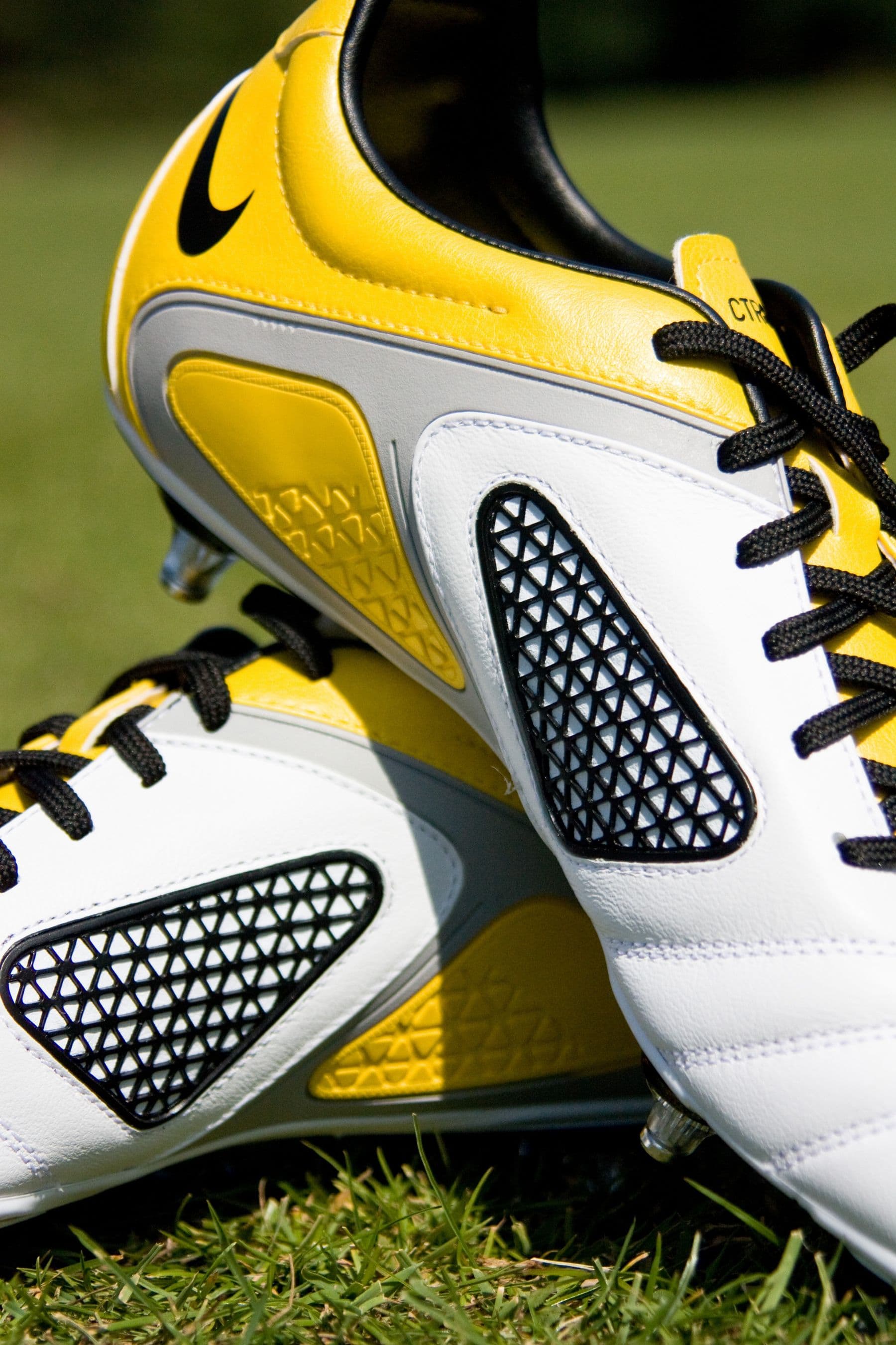 Yellow and black football boots on grass